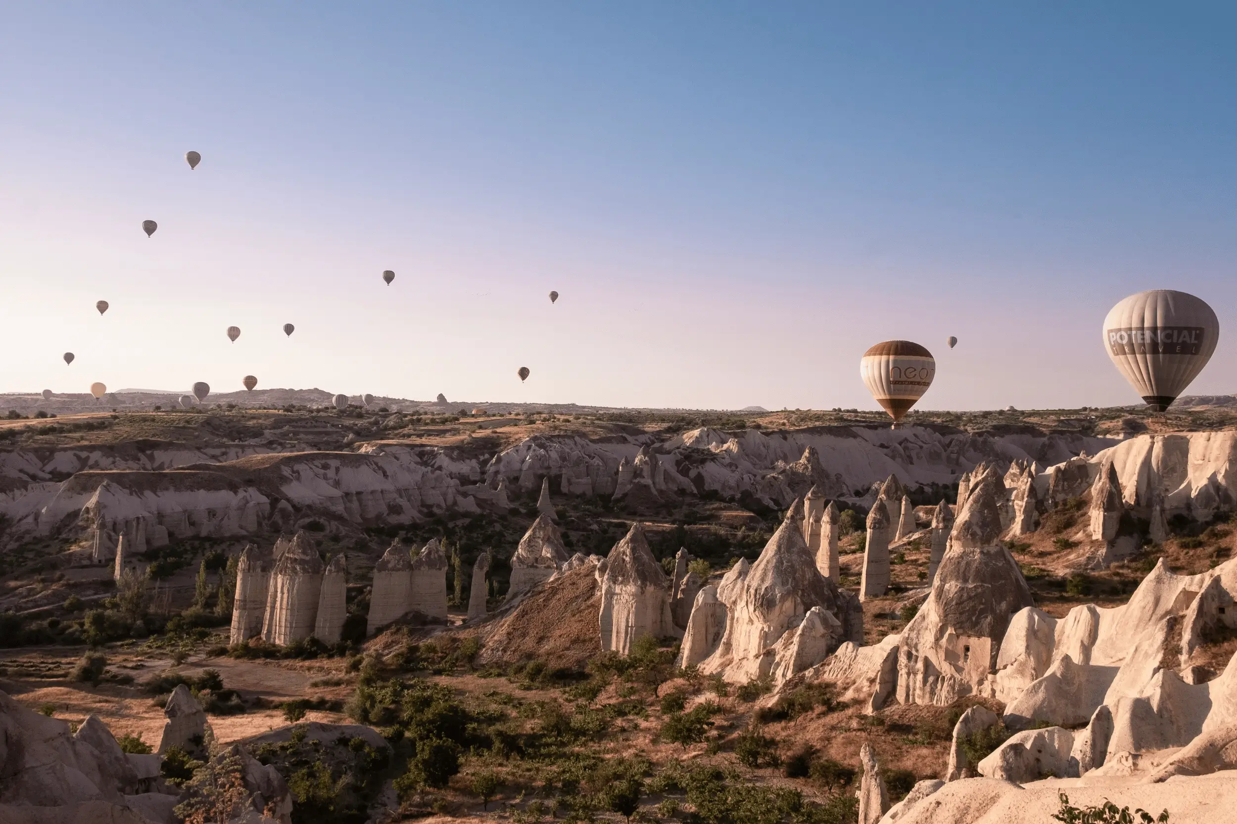 Hot air balloons rising over the rock formations of Cappadocia at dawn